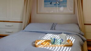 A bed with a tray of croissants, two mugs, and a teapot on a wooden tray. - 1 Bed in Alnwick (oc-cn212) (Bilton)