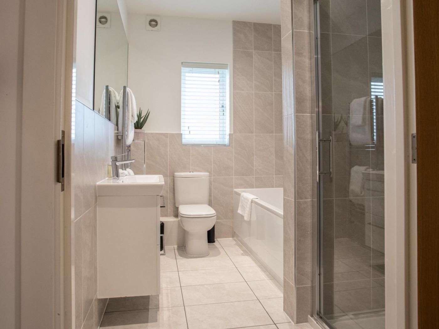 Une salle de bain moderne équipée de toilettes, d’un lavabo et d’un espace douche.