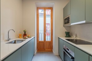 Cocina compacta con pileta, cocina y microondas.