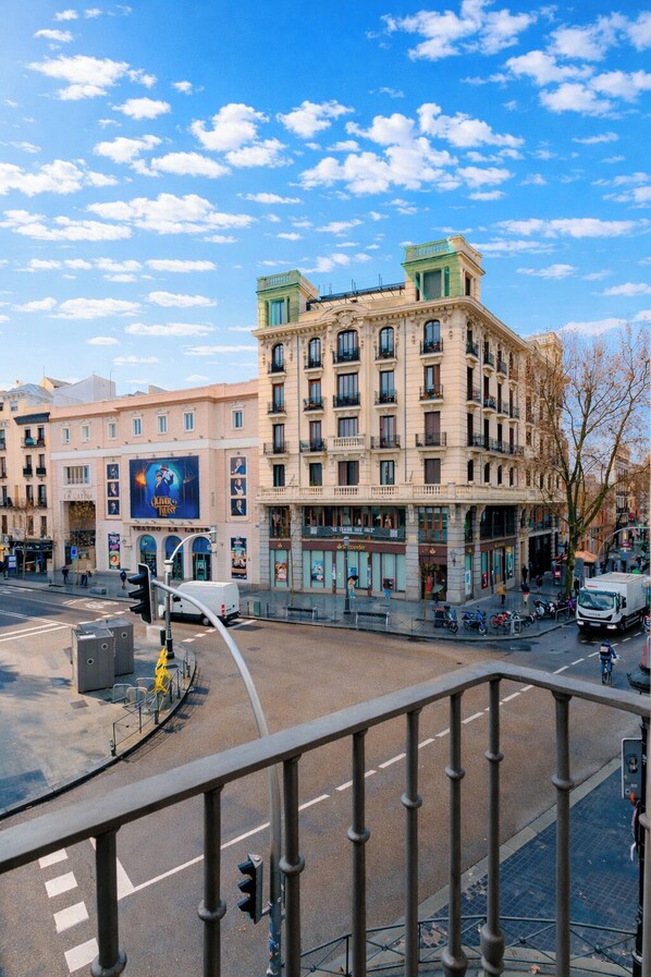 Un edificio de varios pisos con estilo arquitectónico clásico, que cuenta con un patio central y vista a la calle.