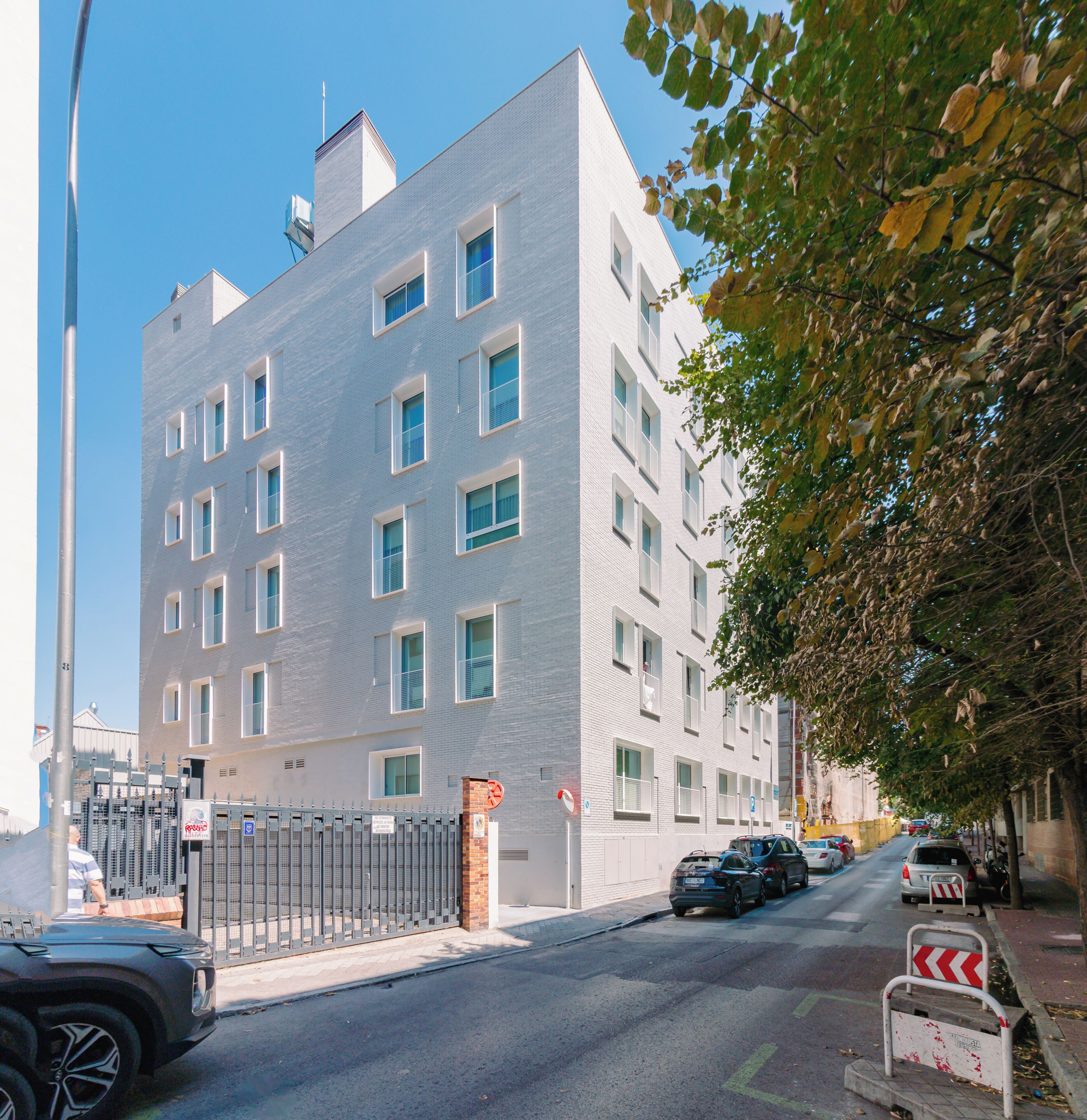 Um edifício com vários andares, design arquitetônico moderno, com uma fachada de tijolos e uma série de janelas.