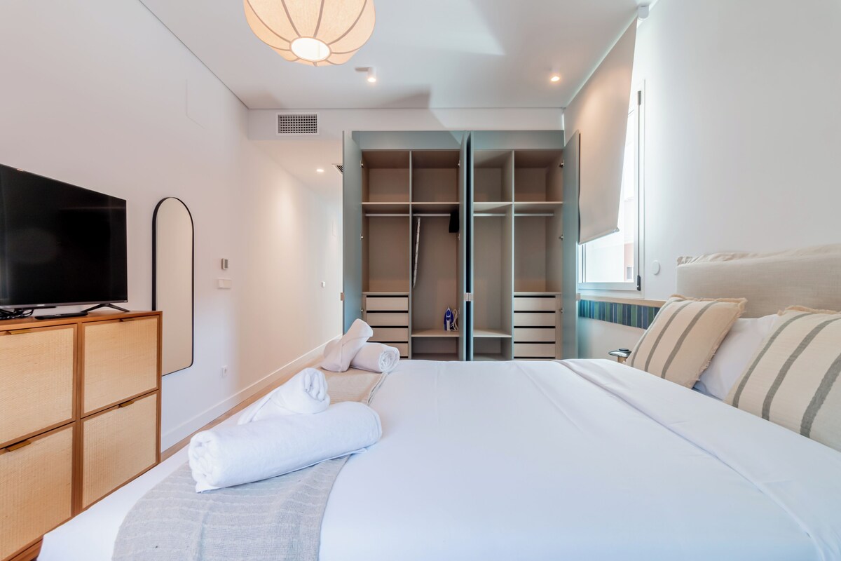 Habitación de hotel con cama, televisión, armario y vestidor.