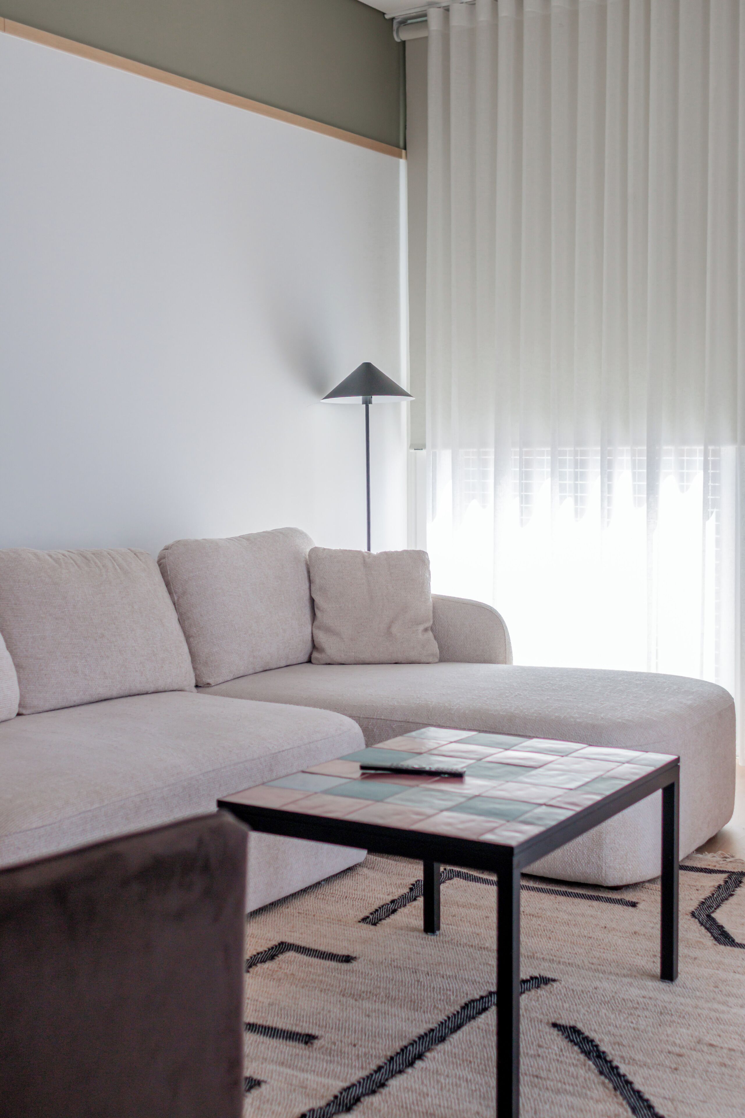 Un salon avec un canapé, une table basse et un lampadaire.