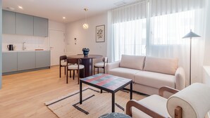 En moderne stue med sofa, sofabord og spiseplads med stole.