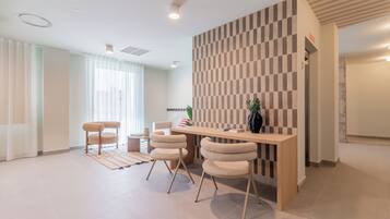 Een moderne receptiebalie met een geruit wandpaneel, een houten toonbank en twee stoelen.