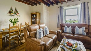 A living room with a wooden ceiling, a dining area with a table and chairs, and a window with curtains. - 2 Bed in Alnwick (oc-60464) (Boulmer)