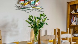 A wooden dining table with plates, glasses, and a vase of flowers. - 2 Bed in Alnwick (oc-60464) (Boulmer)