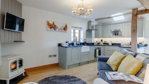 Une cuisine moderne avec des meubles gris, un four encastré et un grand îlot central.