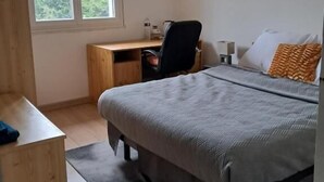 Une chambre à coucher avec un lit, un bureau et une chaise.