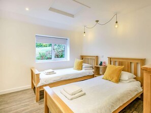 A room with two single beds, a window with a view of greenery, and a skylight. - 2 Bed in Barnstaple (oc-60443) (Bittadon)