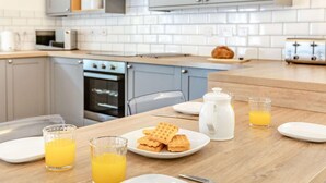 A kitchen with a wooden countertop, a toaster, a waffle plate, a pitcher, and glasses of orange juice. - 2 Bed in Barnstaple (oc-60443) (Bittadon)