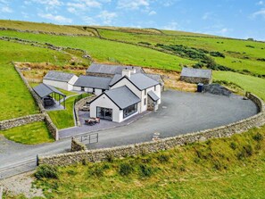 A rural property with multiple buildings, a paved driveway, and stone walls. - 4 Bed in Betws-y-coed (oc-60172) (Pentrefoelas)