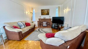 Ein Wohnzimmer mit Kamin, Fernseher und zwei Sofas.