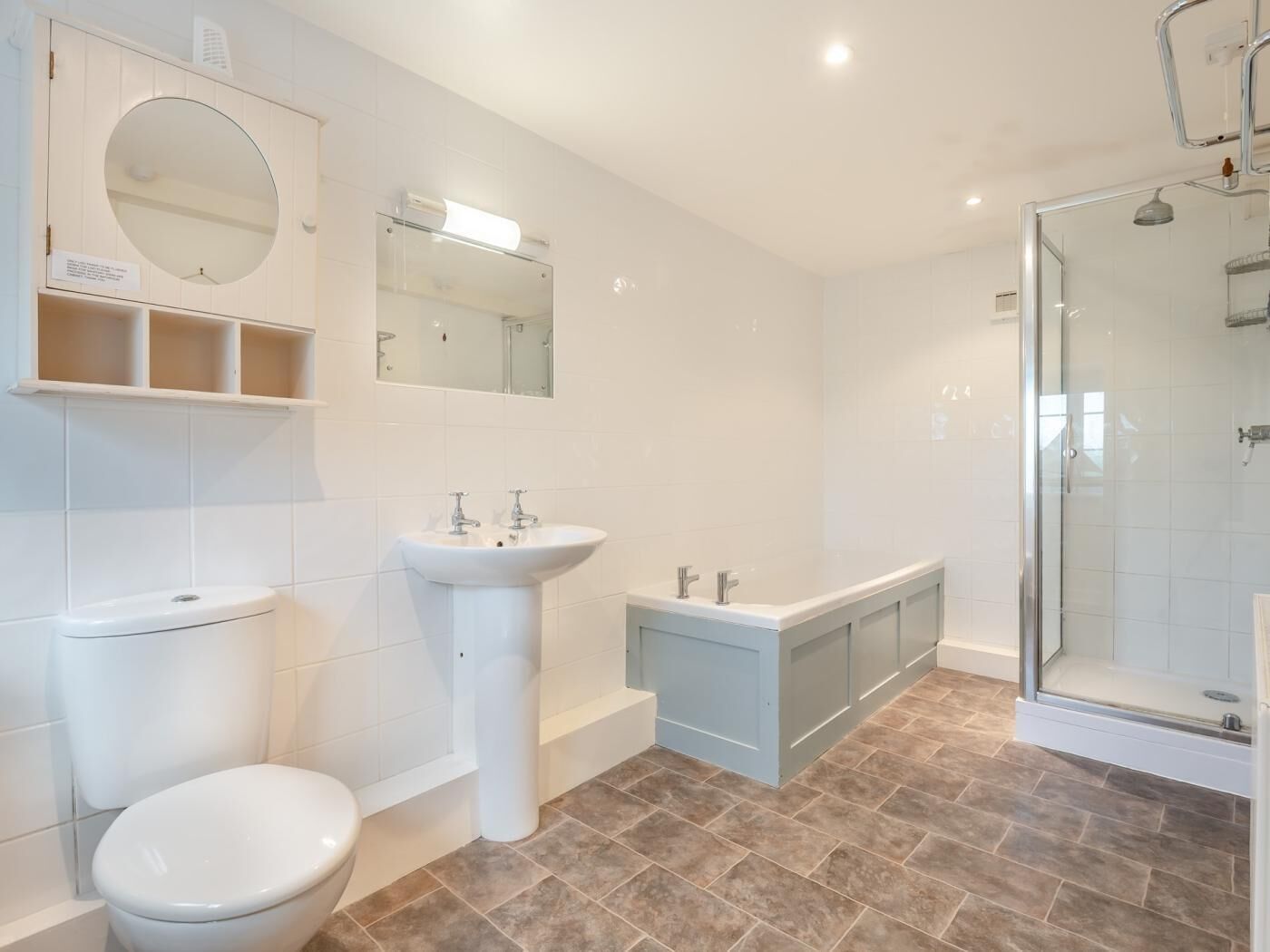 A modern bathroom with a toilet, sink, bathtub, and shower.