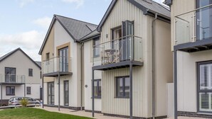 A modern residential building with a flat roof, large windows, and a balcony with a glass railing. - 3 Bed in Westward Ho! (oc-60678) (Westward Ho!)