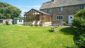 A stone house with a conservatory, a lawn, and a garden. - 3 Bed in Corfe Castle (oc-ic001) (Corfe Castle)