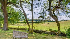 A bench in a grassy area with trees and a stone wall. - 3 Bed in Corfe Castle (oc-ic001) (Corfe Castle)