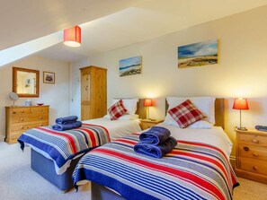A bedroom with two beds, a wooden wardrobe, a mirror, and a painting on the wall. - 2 Bed in Totland Bay (oc-ic003) (Freshwater)