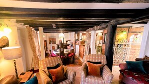 A cozy room with checkered armchairs, a sofa, and a dining area with a table and chairs. - 4 Bed in Godshill (oc-ic034) (Godshill)