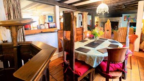 A dining area with a wooden table, chairs, and a chandelier. - 4 Bed in Godshill (oc-ic034) (Godshill)