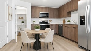 Una cucina moderna con isola centrale, elettrodomestici integrati e zona pranzo con sedie.