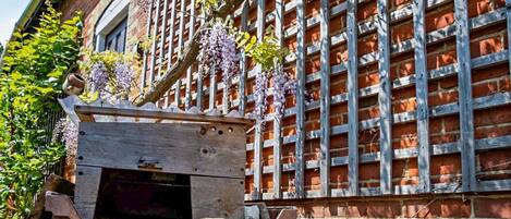 Un bâtiment en briques avec une pergola en bois et un banc en bois.