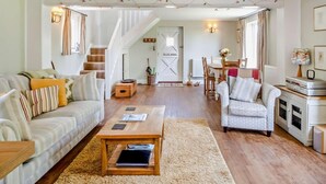 A spacious living area with a sofa, armchair, coffee table, and a staircase leading to another room. - 1 Bed in Cowes (oc-ic084) (Cowes)