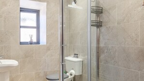 A bathroom with a glass-enclosed shower, a toilet, a sink, and a window with a vase. - 2 Bed in Godshill (oc-ic085) (Godshill)