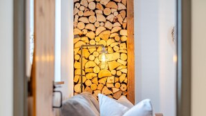 Ein gemütliches Zimmer mit einer Holzwand, einer bequemen Couch und einer Wandleuchte.