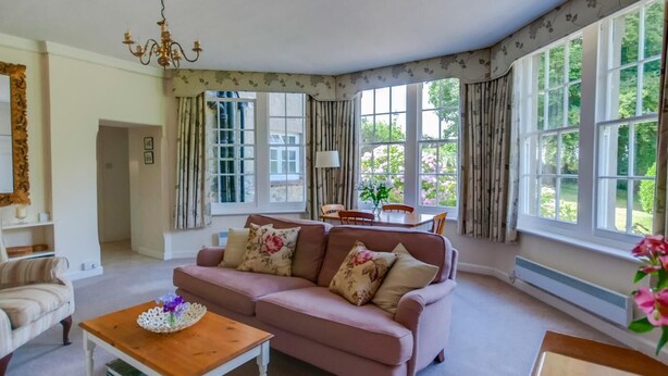 A living room with a sofa, a coffee table, and a dining area with a table and chairs. - 1 Bed in Godshill (oc-ic052) (Godshill)