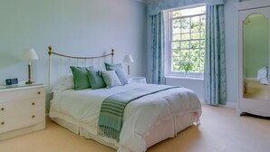 A bedroom with a bed, bedside tables, a window with curtains, and a wardrobe. - 1 Bed in Godshill (oc-ic052) (Godshill)
