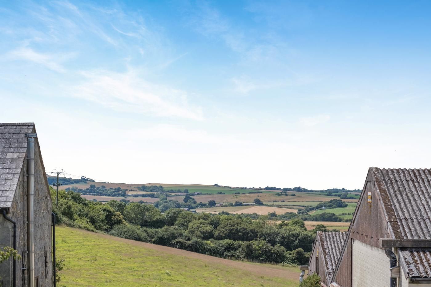 A rural landscape with a view of rolling hills and a clear sky.
