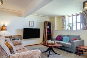 A living room with a sofa, a television, a coffee table, and a bookshelf. - 2 Bed in Godshill (oc-ic106) (Godshill)