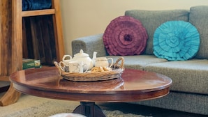 A round wooden table with a basket containing a teapot, cups, and a jug. - 2 Bed in Godshill (oc-ic106) (Godshill)