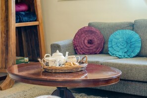 A round wooden table with a basket containing a teapot, cups, and a jug. - 2 Bed in Godshill (oc-ic106) (Godshill)