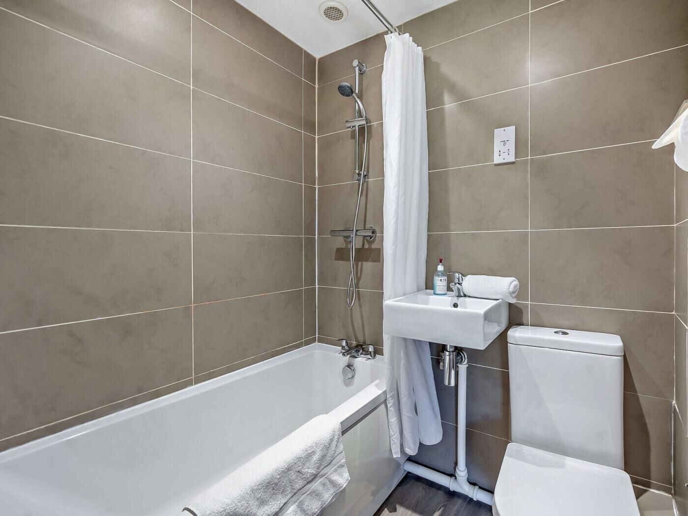 Un baño moderno con bañera, ducha, lavabo e inodoro.