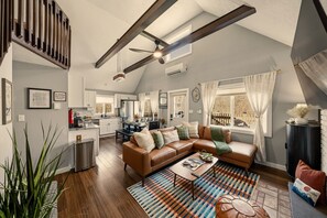 A spacious living area with a large brown leather sofa, a coffee table, and a colorful rug. - GameRoom•FirePit•Grill•KidsFriendly•9 min Kalahari (Long Pond)