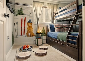 A cozy room with bunk beds, a wall mural, and a small table with a lamp. - GameRoom•FirePit•Grill•KidsFriendly•9 min Kalahari (Long Pond)