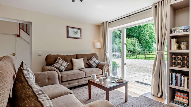 A living room with a sofa, a coffee table, and a bookshelf. - 3 Bed in Sturminster Newton (oc-rcorn) (Sturminster Newton)