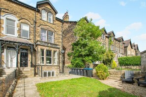 A row of terraced houses with a grassy front yard and a tree. - 1 Bed in Harrogate (oc-hh055) (Harrogate)