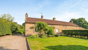 A stone house with a tiled roof, a gravel driveway, and a well-maintained lawn. - 2 Bed in Northallerton (oc-g0172) (Thimbleby)