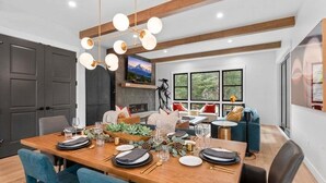 A dining area with a wooden table set for four, surrounded by chairs. - The Riverstone | Luxury Alcove • Kindred • Ski-In/Out • Spa • Heated Garage (Keystone)