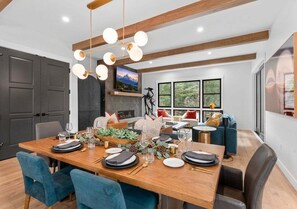 A dining area with a wooden table set for four, surrounded by chairs. - The Riverstone | Luxury Alcove • Kindred • Ski-In/Out • Spa • Heated Garage (Keystone)