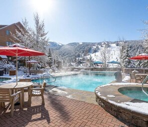 A pool area with a hot tub, outdoor seating, and a view of snow-covered mountains. - The Riverstone | Luxury Alcove • Kindred • Ski-In/Out • Spa • Heated Garage (Keystone)