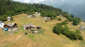 A rural village with traditional houses, a clear sky, and mountains in the background.