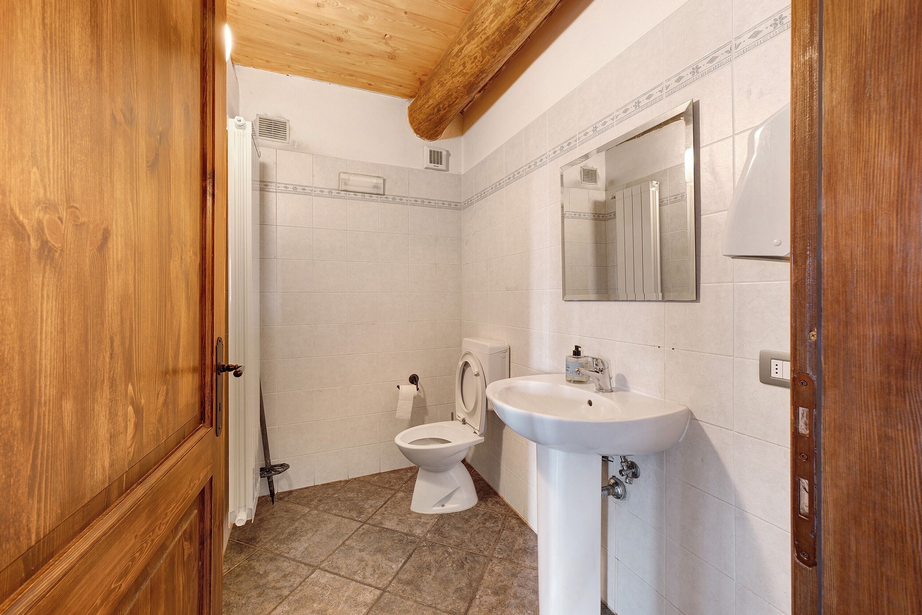 A bathroom with a toilet, sink, and shower.