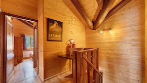 A wooden interior with a framed poster, a wooden bench, and a fire extinguisher.