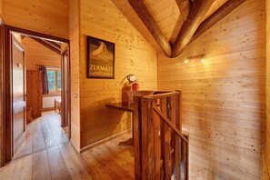 A wooden interior with a framed poster, a wooden bench, and a fire extinguisher.