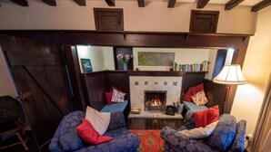 A cozy living room with two armchairs, a fireplace, and a bookshelf. - 2 Bed in Swanage (oc-dc069) (Studland)