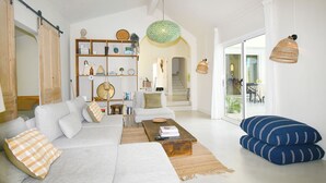 Una sala de estar con un sofá, una mesa de centro y almohadones decorativos.